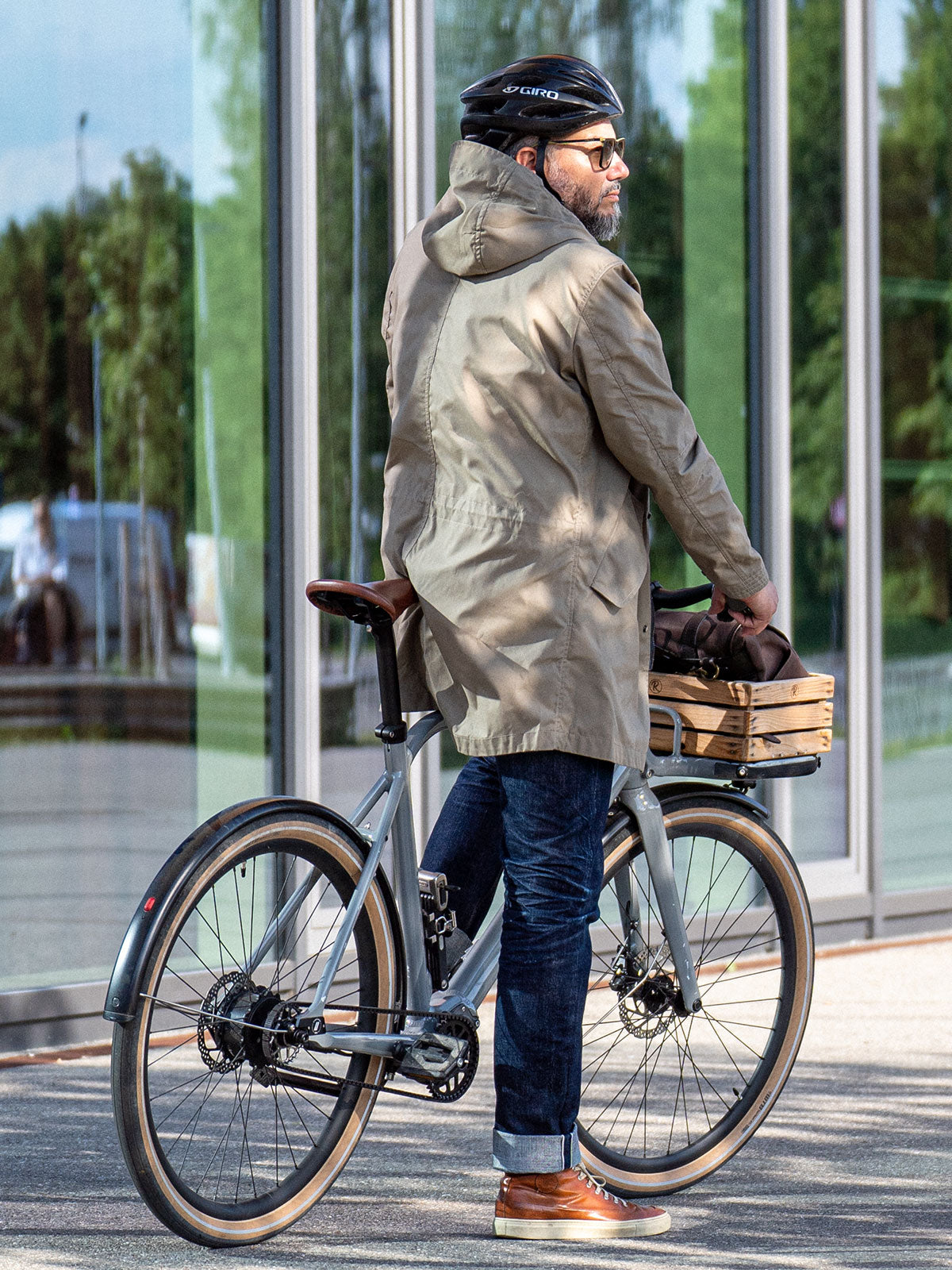 Ein Mann fährt auf einem E-BIKE und trägt einen abriebfesten Parka der Marke For-Legends by Caduff, ideal für urban mobility - for-legends.com. A man rides an E-BIKE wearing an abrasion-resistant parka by For-Legends by Caduff, ideal for urban mobility - for-legends.com.