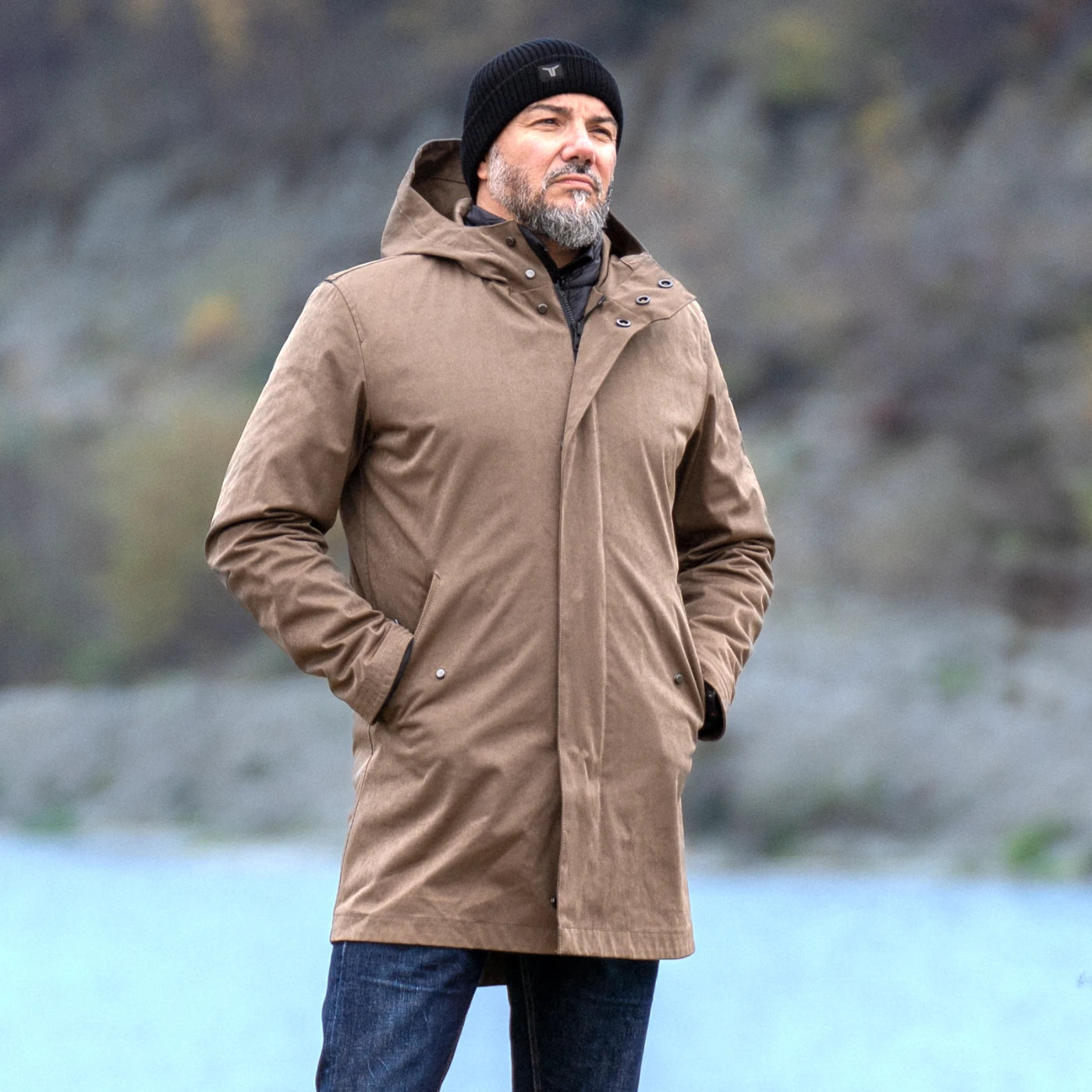 Brown CADUFF Japanese Double-Knit 2-in-1 Winter Parka in front of a winter lake; premium FOR LEGENDS presentation, water-repellent and wind-resistant.