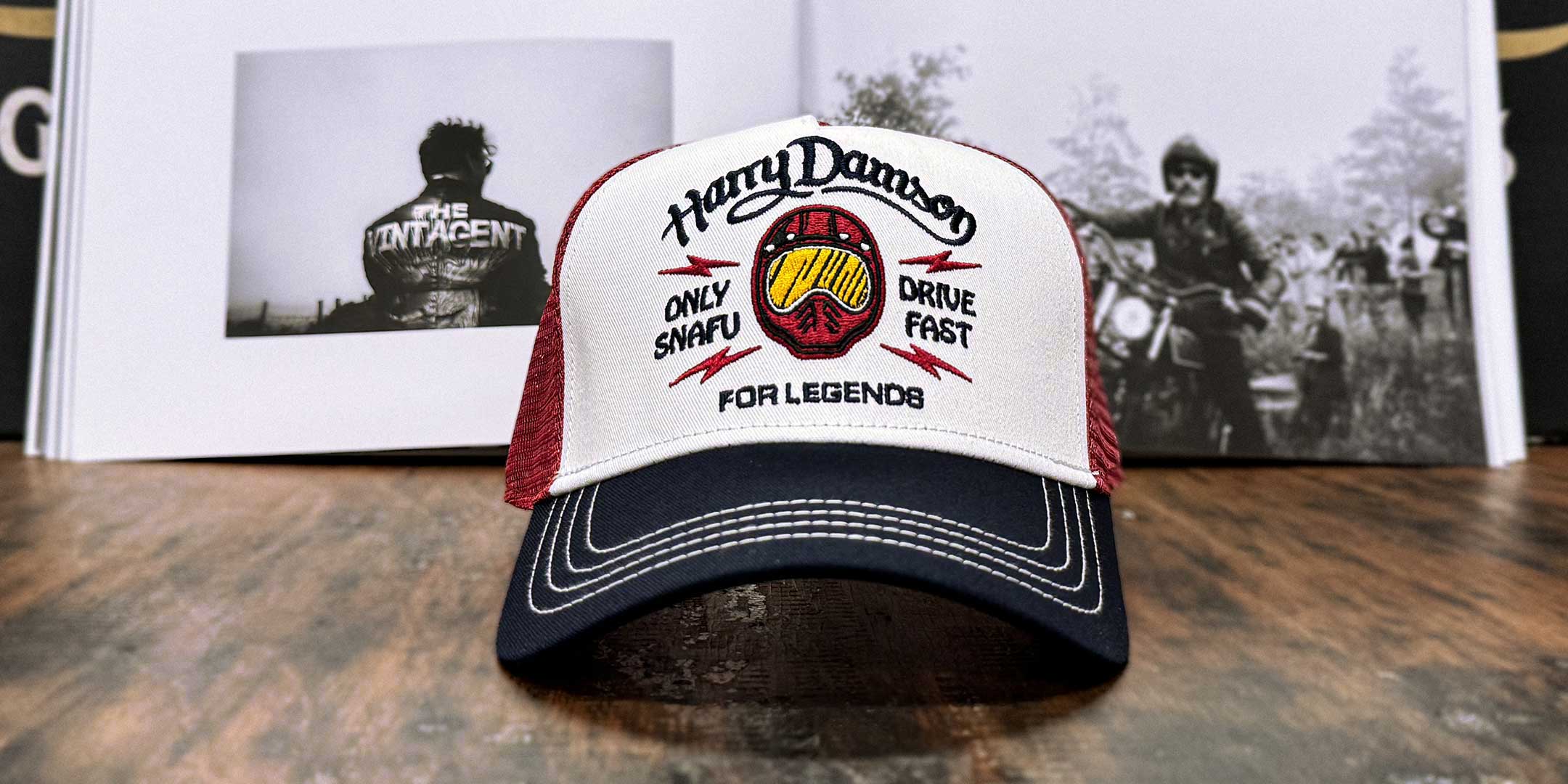Burgunderfarbene Trucker Cap im Streetwear-Look mit Frontansicht, Motorradfahrer im Hintergrund, For Legends x Harry Damson