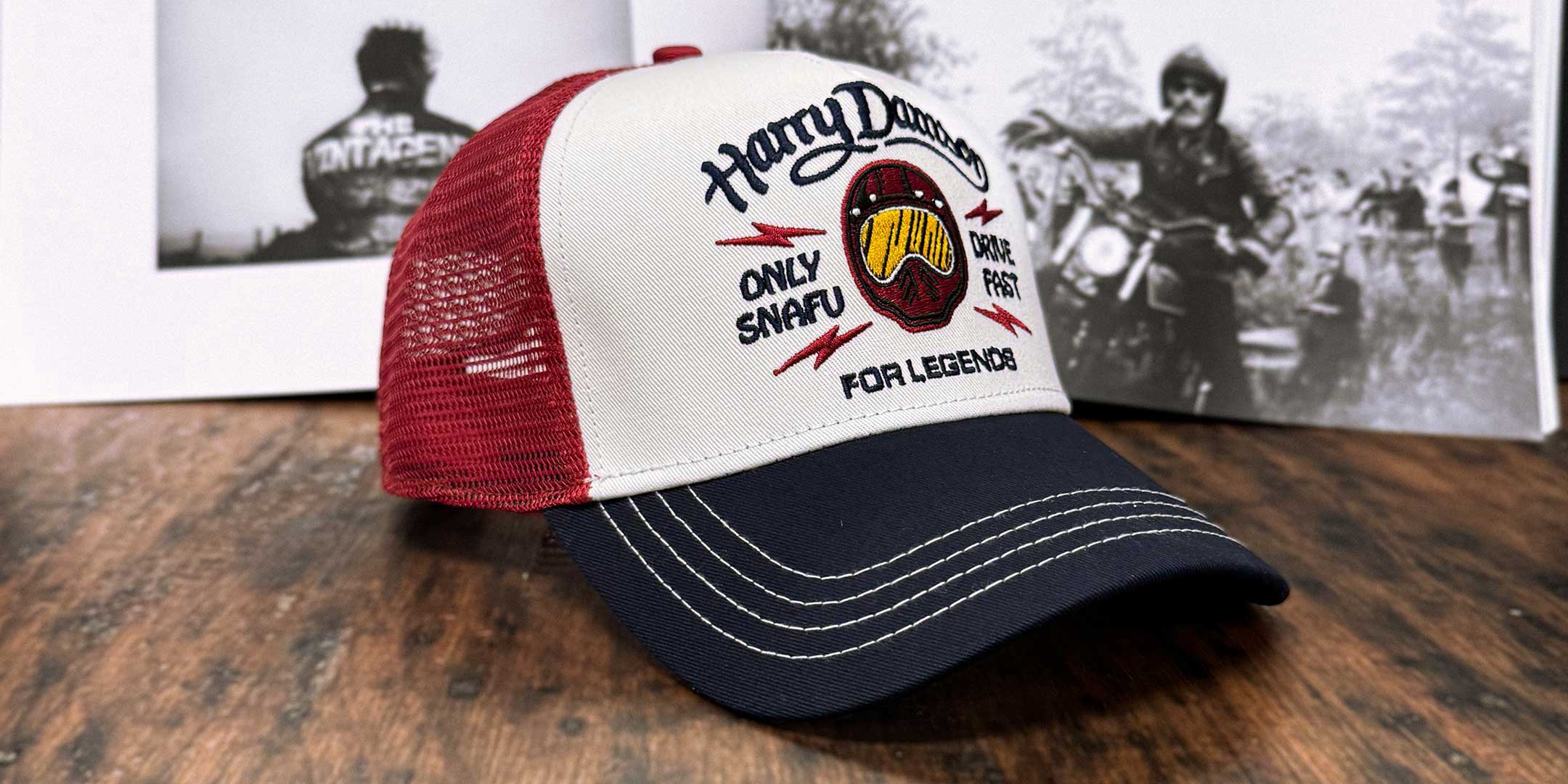 Burgunderfarbene Trucker Cap in schräger Seitenansicht mit Biker, der die Arme ausstreckt, For Legends x Harry Damson