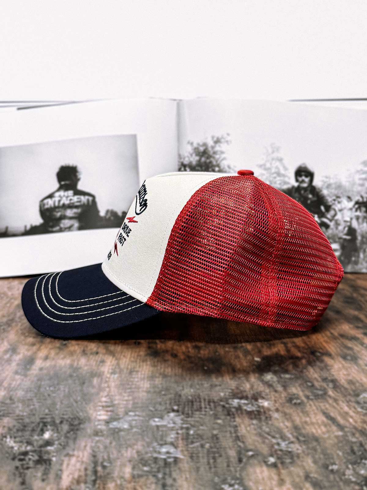 Burgunderfarbene Trucker Cap von der Seite, mit dem Buch 'Wall of Death' im Hintergrund, For Legends x Harry Damson