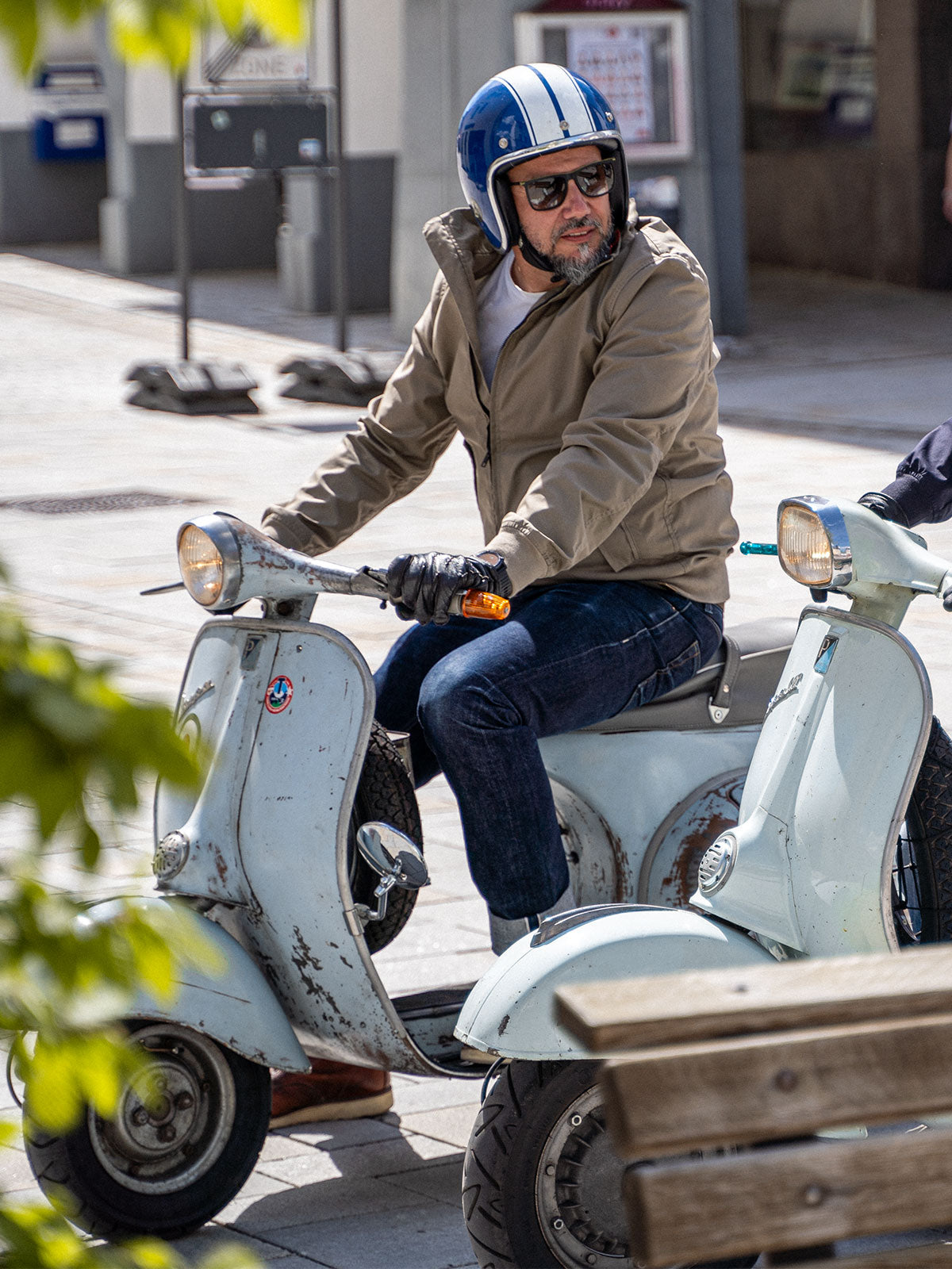 Ein Mann fährt auf einer Vespa und trägt einen abriebfesten Blouson der Marke For-Legends by Caduff, ideal für urban mobility - for-legends.com. A man rides a Vespa wearing an abrasion-resistant Blouson by For-Legends by Caduff, ideal for urban mobility - for-legends.com