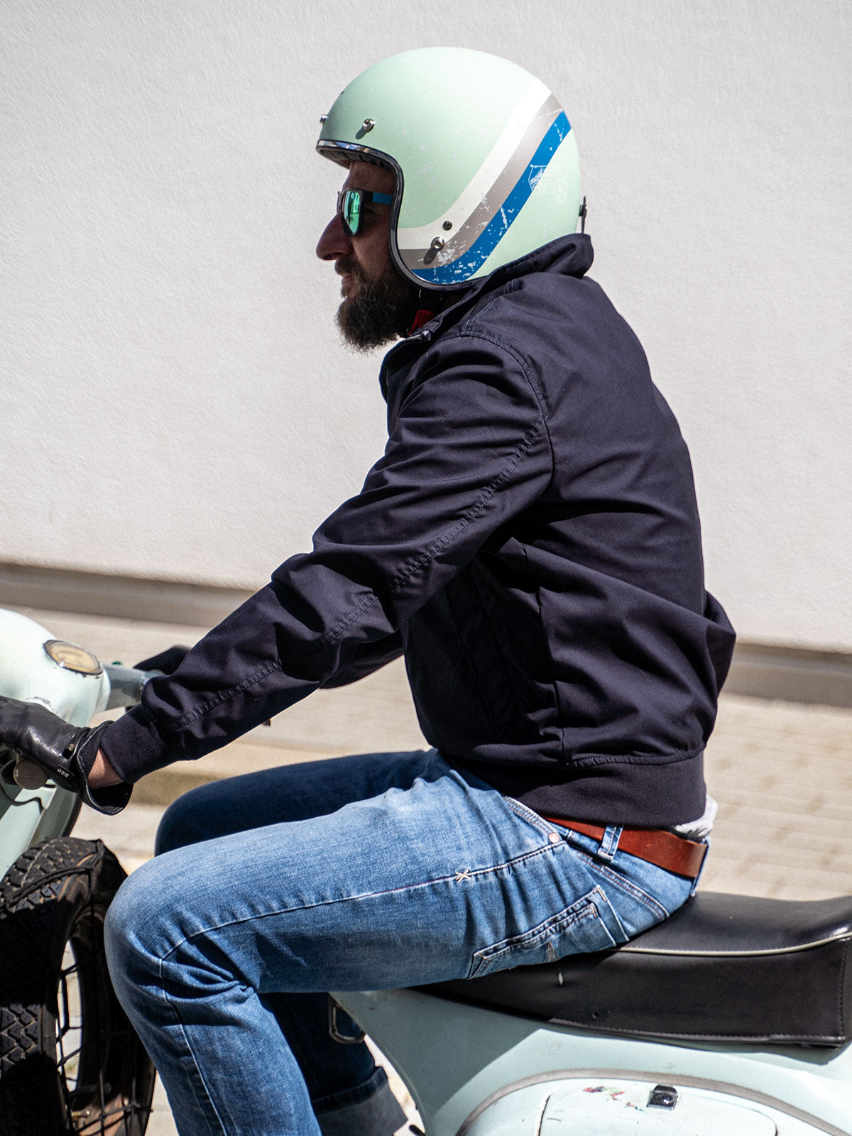 Ein Mann fährt auf einer Vespa und trägt einen abriebfesten Blouson der Marke For-Legends by Caduff, ideal für urban mobility - for-legends.com. A man rides a Vespa wearing an abrasion-resistant Blouson by For-Legends by Caduff, ideal for urban mobility - for-legends.com