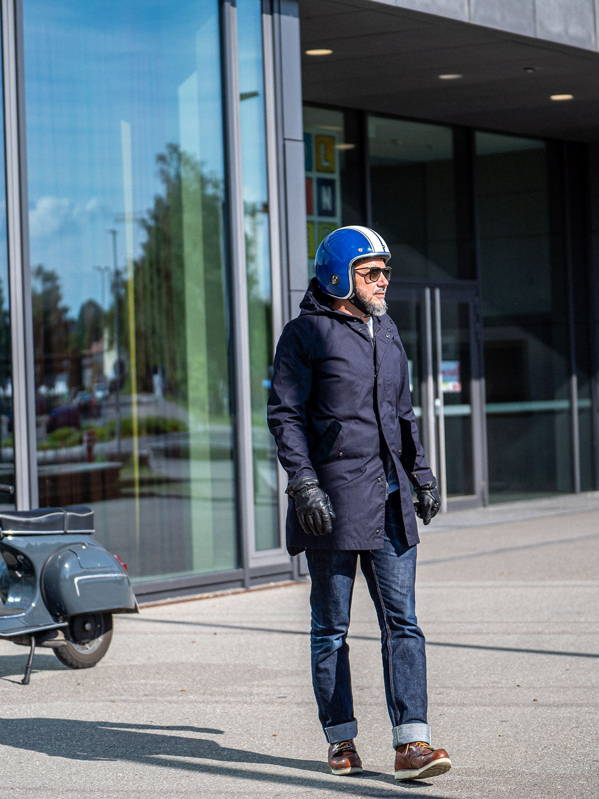 Ein Mann fährt auf einer Vespa | Scooter und trägt einen abriebfesten Parka der Marke For-Legends by Caduff, ideal für urban mobility - for-legends.com. A man rides on a Vespa / Scooter wearing an abrasion-resistant parka by For-Legends by Caduff, ideal for urban mobility - for-legends.com