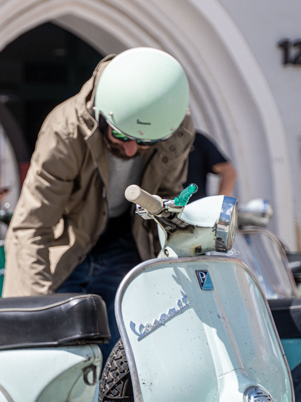 Ein Mann fährt auf einer Vespa | Scooter und trägt einen abriebfesten Parka der Marke For-Legends by Caduff, ideal für urban mobility - for-legends.com. A man rides on a Vespa / Scooter wearing an abrasion-resistant parka by For-Legends by Caduff, ideal for urban mobility - for-legends.com