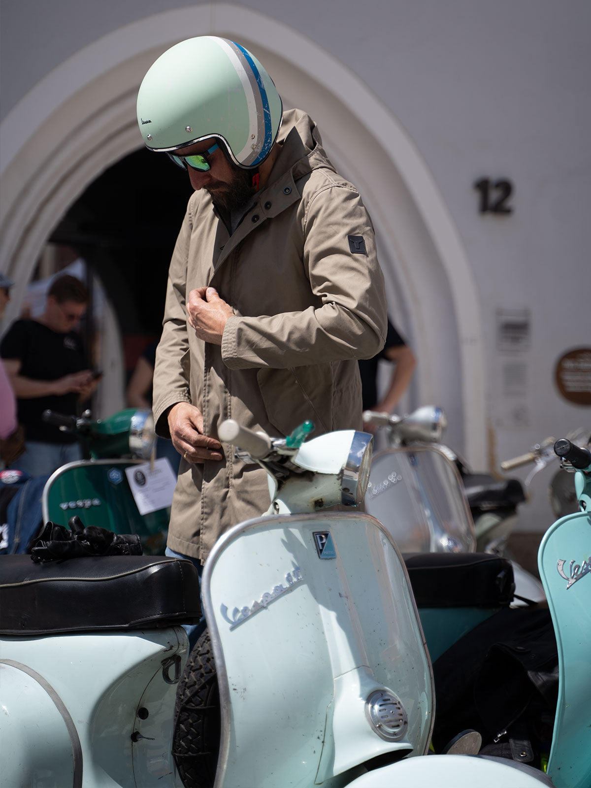 Ein Mann fährt auf einer Vespa | Scooter und trägt einen abriebfesten Parka der Marke For-Legends by Caduff, ideal für urban mobility - for-legends.com. A man rides on a Vespa / Scooter wearing an abrasion-resistant parka by For-Legends by Caduff, ideal for urban mobility - for-legends.com