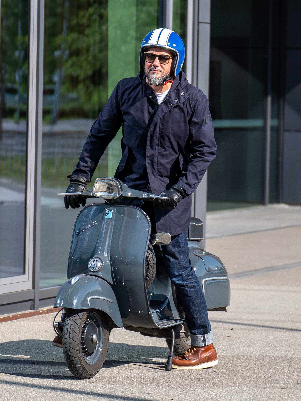 Ein Mann fährt auf einer Vespa | Scooter und trägt einen abriebfesten Parka der Marke For-Legends by Caduff, ideal für urban mobility - for-legends.com. A man rides on a Vespa / Scooter wearing an abrasion-resistant parka by For-Legends by Caduff, ideal for urban mobility - for-legends.com