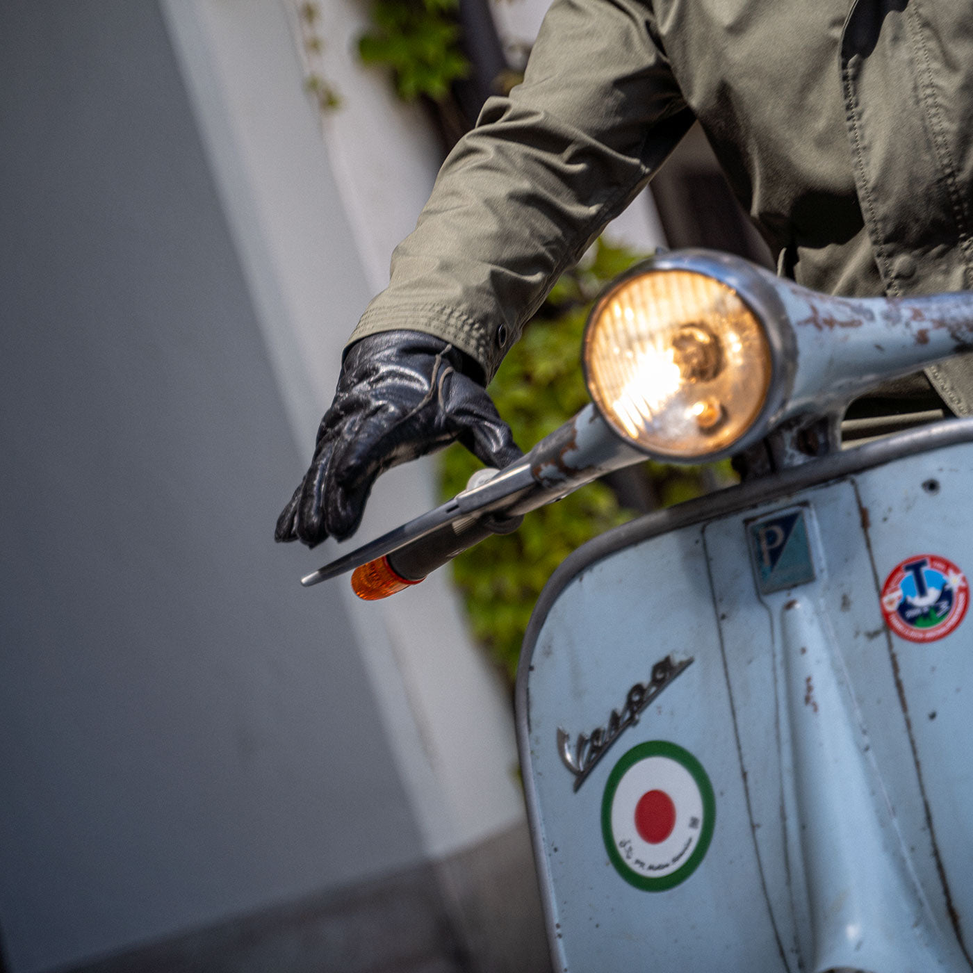Ein Mann fährt auf einer Vespa und trägt einen abriebfesten Parka der Marke For-Legends by Caduff, ideal für urban mobility - for-legends.com. A man rides a Vespa wearing an abrasion-resistant parka by For-Legends by Caduff, ideal for urban mobility - for-legends.com.