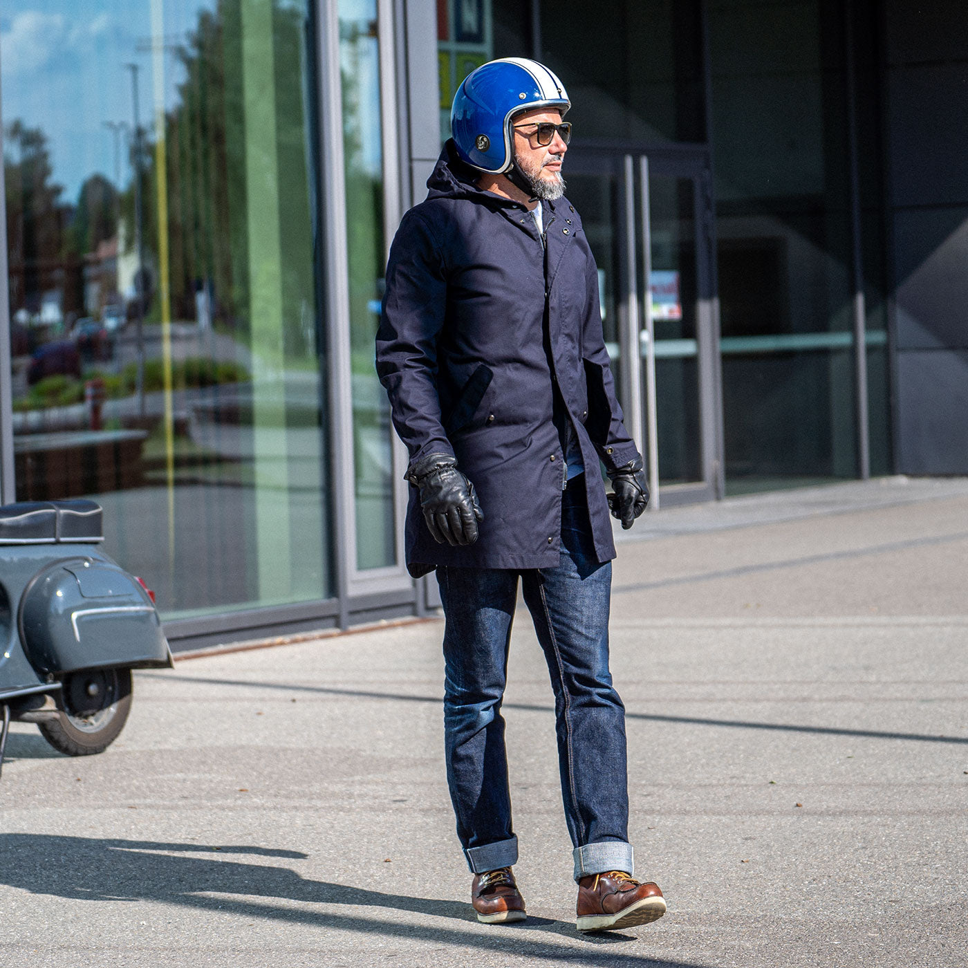 Ein Mann fährt auf einer Vespa und trägt einen abriebfesten Parka der Marke For-Legends by Caduff, ideal für urban mobility - for-legends.com. A man rides a Vespa wearing an abrasion-resistant parka by For-Legends by Caduff, ideal for urban mobility - for-legends.com.