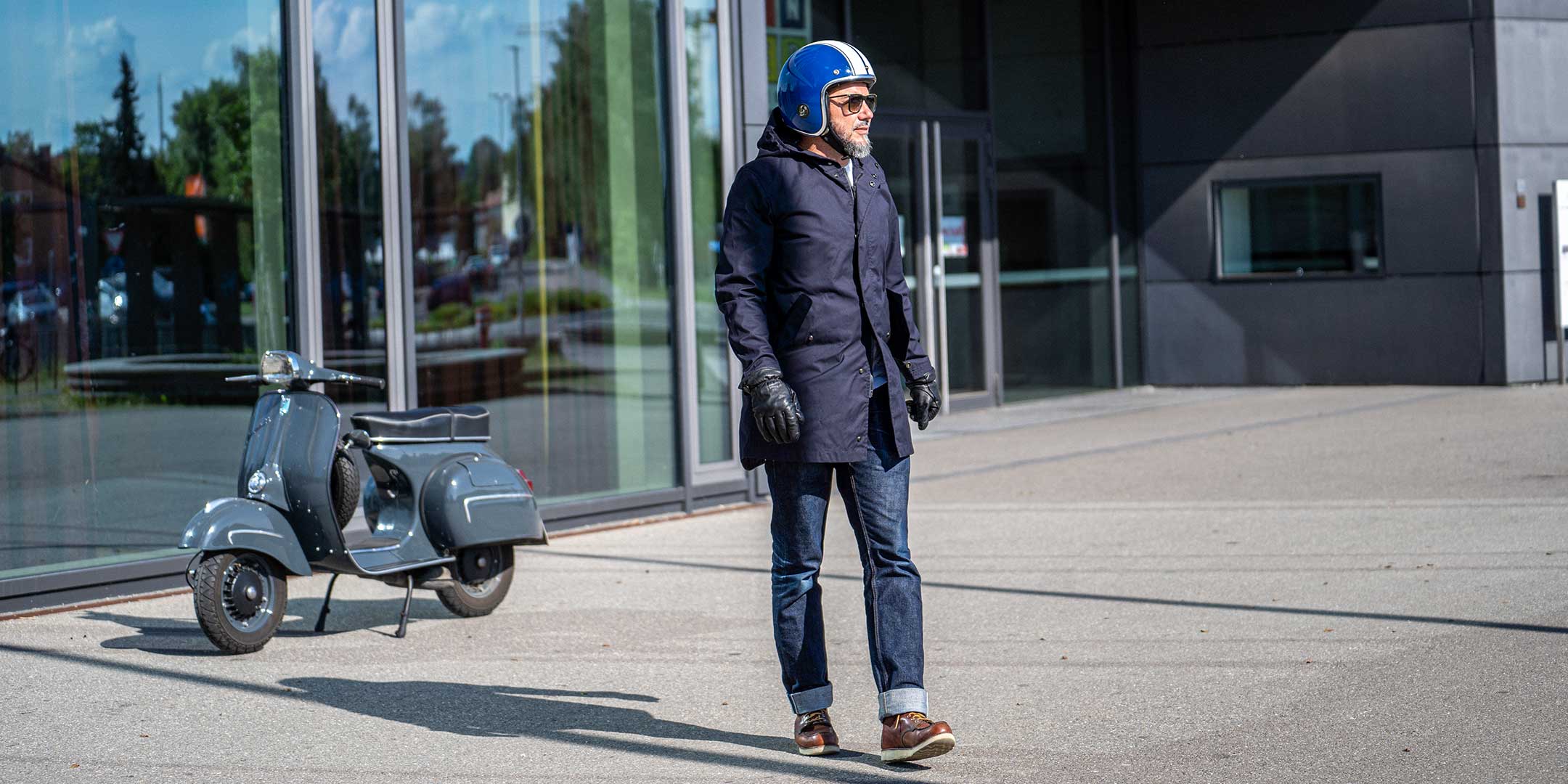 Ein Mann fährt auf einer Vespa | Scooter und trägt einen abriebfesten Parka der Marke For-Legends by Caduff, ideal für urban mobility - for-legends.com. A man rides on a Vespa / Scooter wearing an abrasion-resistant parka by For-Legends by Caduff, ideal for urban mobility - for-legends.com