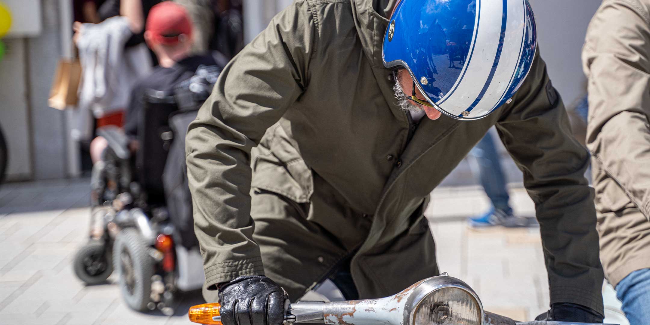 Ein Mann fährt auf einer Vespa | Scooter und trägt einen abriebfesten Parka der Marke For-Legends by Caduff, ideal für urban mobility - for-legends.com. A man rides on a Vespa / Scooter wearing an abrasion-resistant parka by For-Legends by Caduff, ideal for urban mobility - for-legends.com