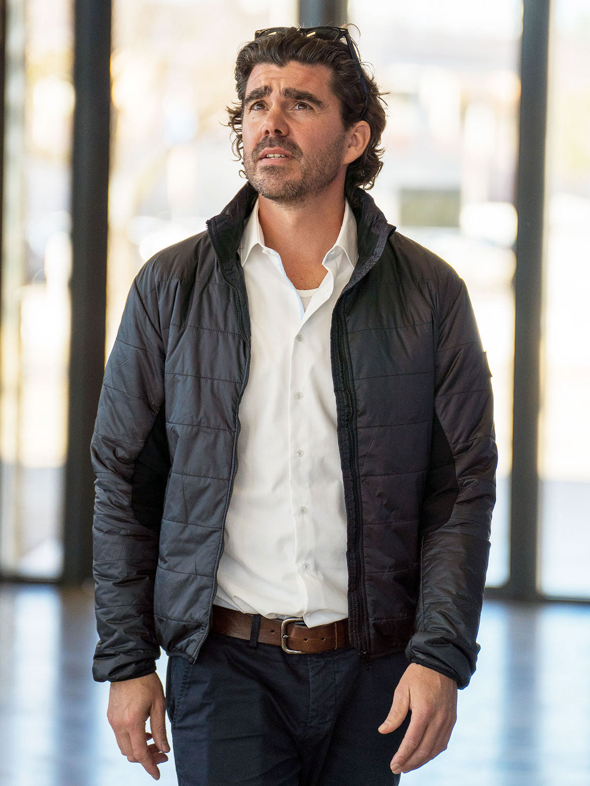 MODEL WALKING IN THE TRAINSTATION WEARING A ECO DOWN INSULATION JACKET WITH 100% RECYLED FIBRES FROM PET BOTTLES