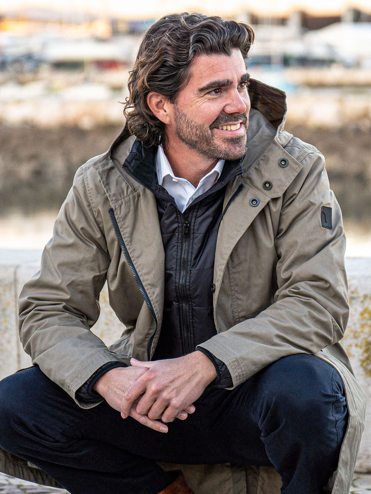 MODEL KNIING ON A RIVER WEARING AN URBAN MOBILITY PARKA WITH AN ABRASSION RESISTANCE UP TO A SPEED OF 45 KM/H