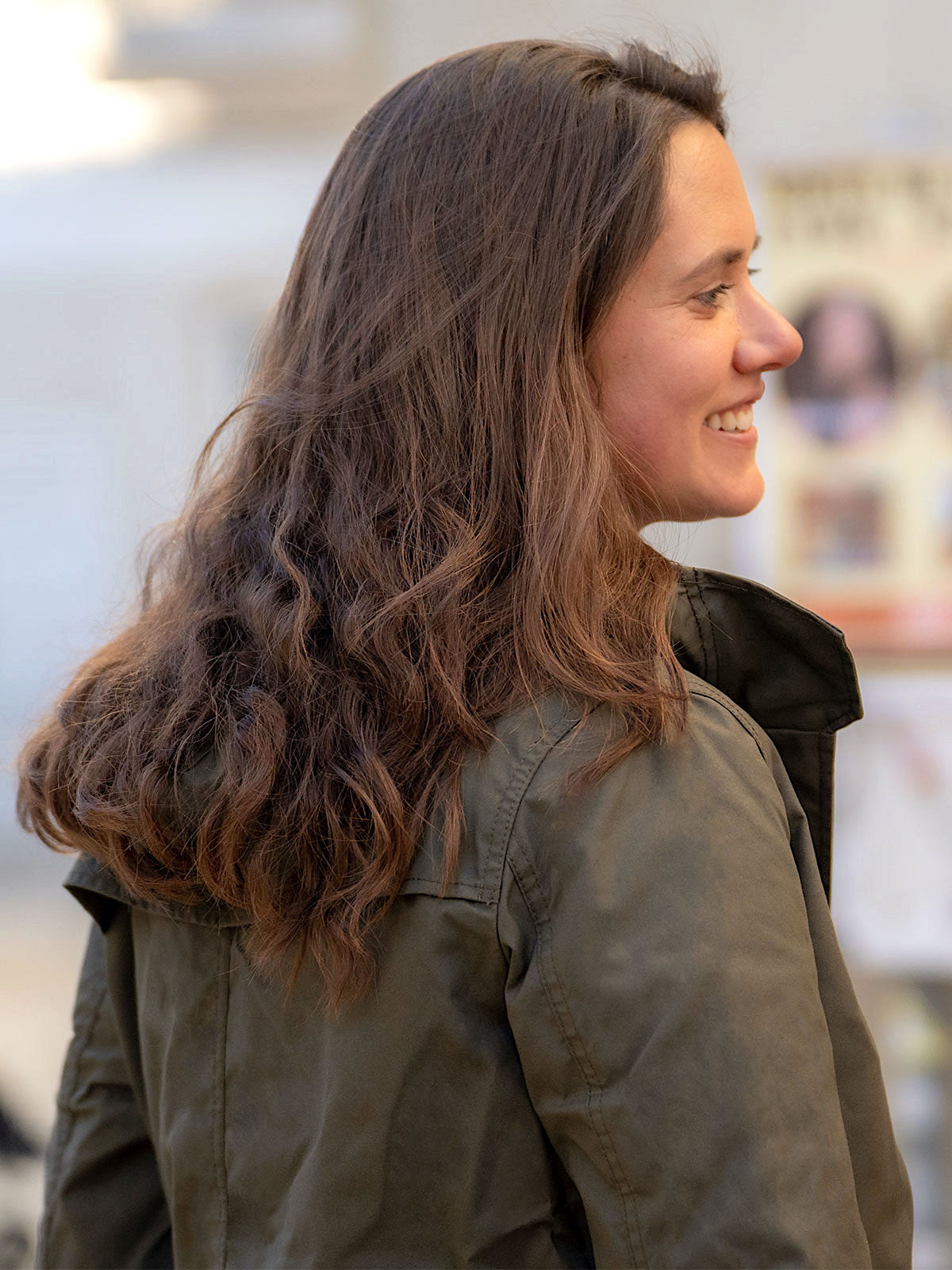 WOMAN WALKING AT THE HARBER WEARING AN URBAN MOBILITY PARKA WITH AN ABRASSION RESISTANCE UP TO A SPEED OF 45 KM/H