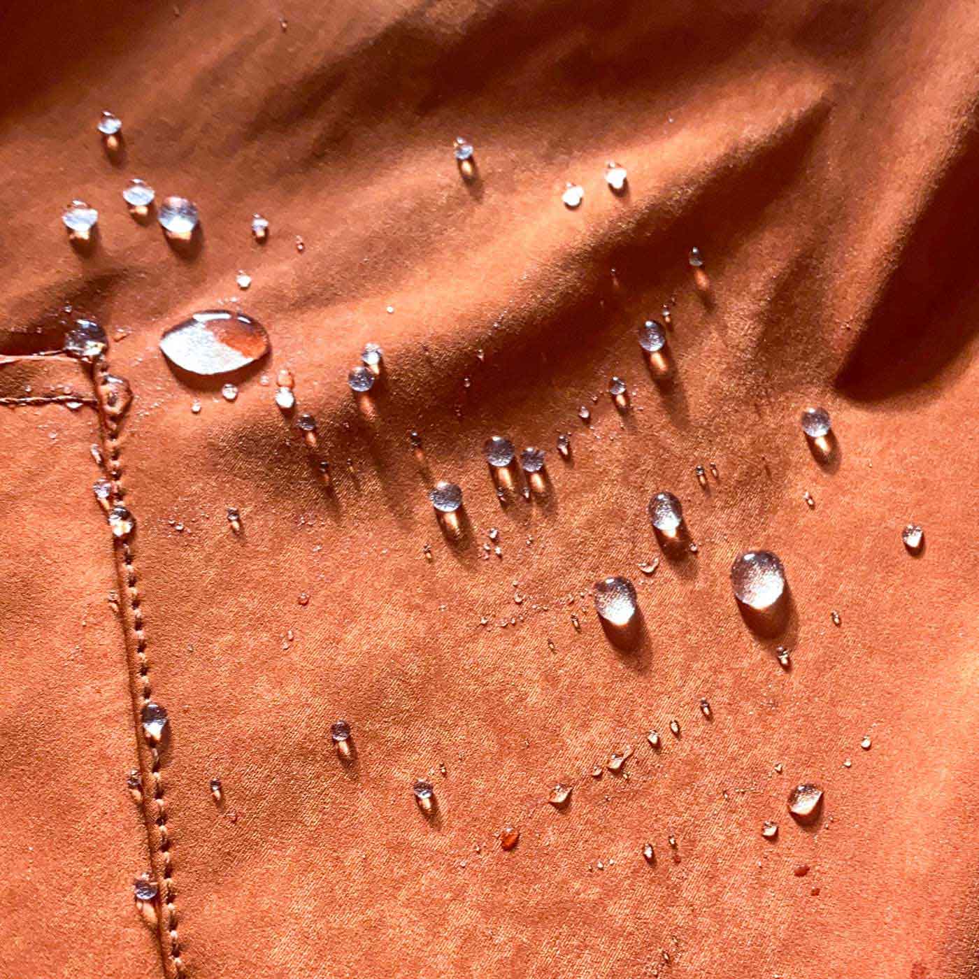 Close-up of the Ginger Japanese high-density double-knit on the CADUFF Shirase 2-in-1 Winter Parka, showing breathable structure with water-repellent beads (C6 finish).