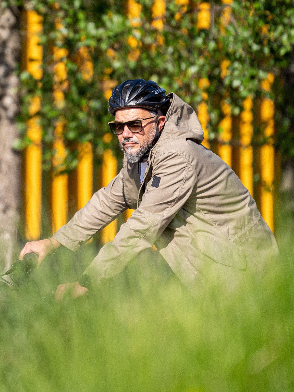 Ein Mann fährt auf einem E-BIKE und trägt einen abriebfesten Parka der Marke For-Legends by Caduff, ideal für urban mobility - for-legends.com. A man rides an E-BIKE wearing an abrasion-resistant parka by For-Legends by Caduff, ideal for urban mobility - for-legends.com.