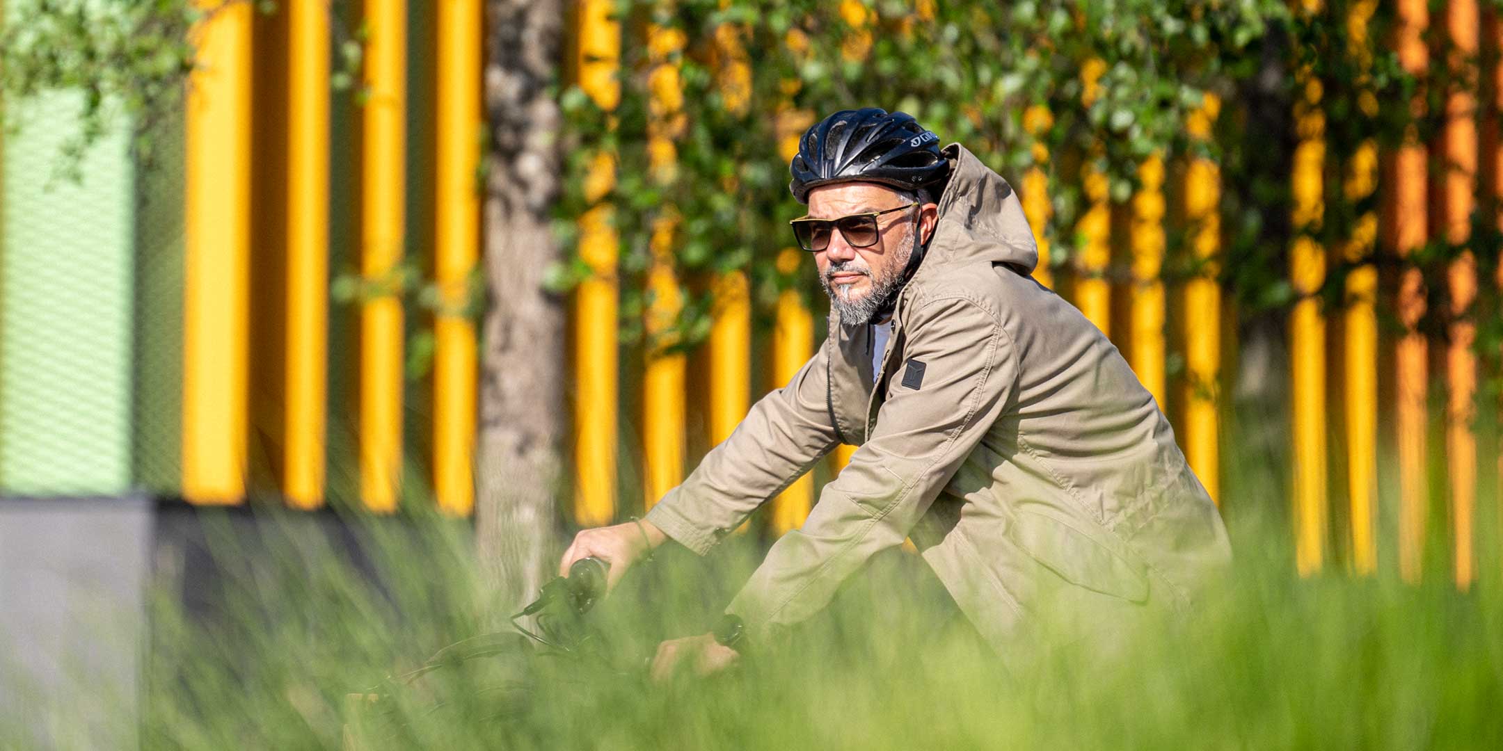 Ein Mann fährt auf einem E-BIKE und trägt einen abriebfesten Parka der Marke For-Legends by Caduff, ideal für urban mobility - for-legends.com. A man rides an E-BIKE wearing an abrasion-resistant parka by For-Legends by Caduff, ideal for urban mobility - for-legends.com.