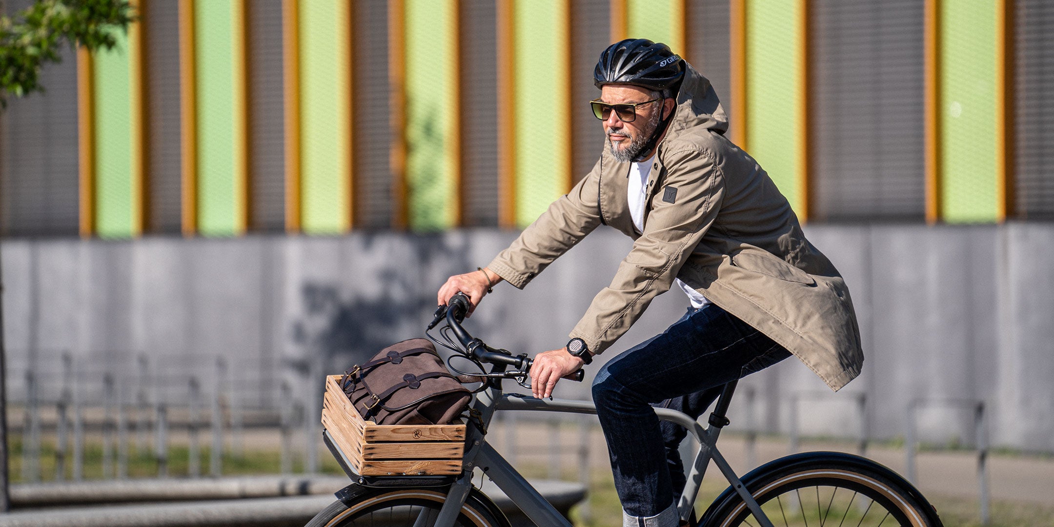 Ein Mann fährt auf einem E-BIKE und trägt einen abriebfesten Parka der Marke For-Legends by Caduff, ideal für urban mobility - for-legends.com. A man rides an E-BIKE wearing an abrasion-resistant parka by For-Legends by Caduff, ideal for urban mobility - for-legends.com.