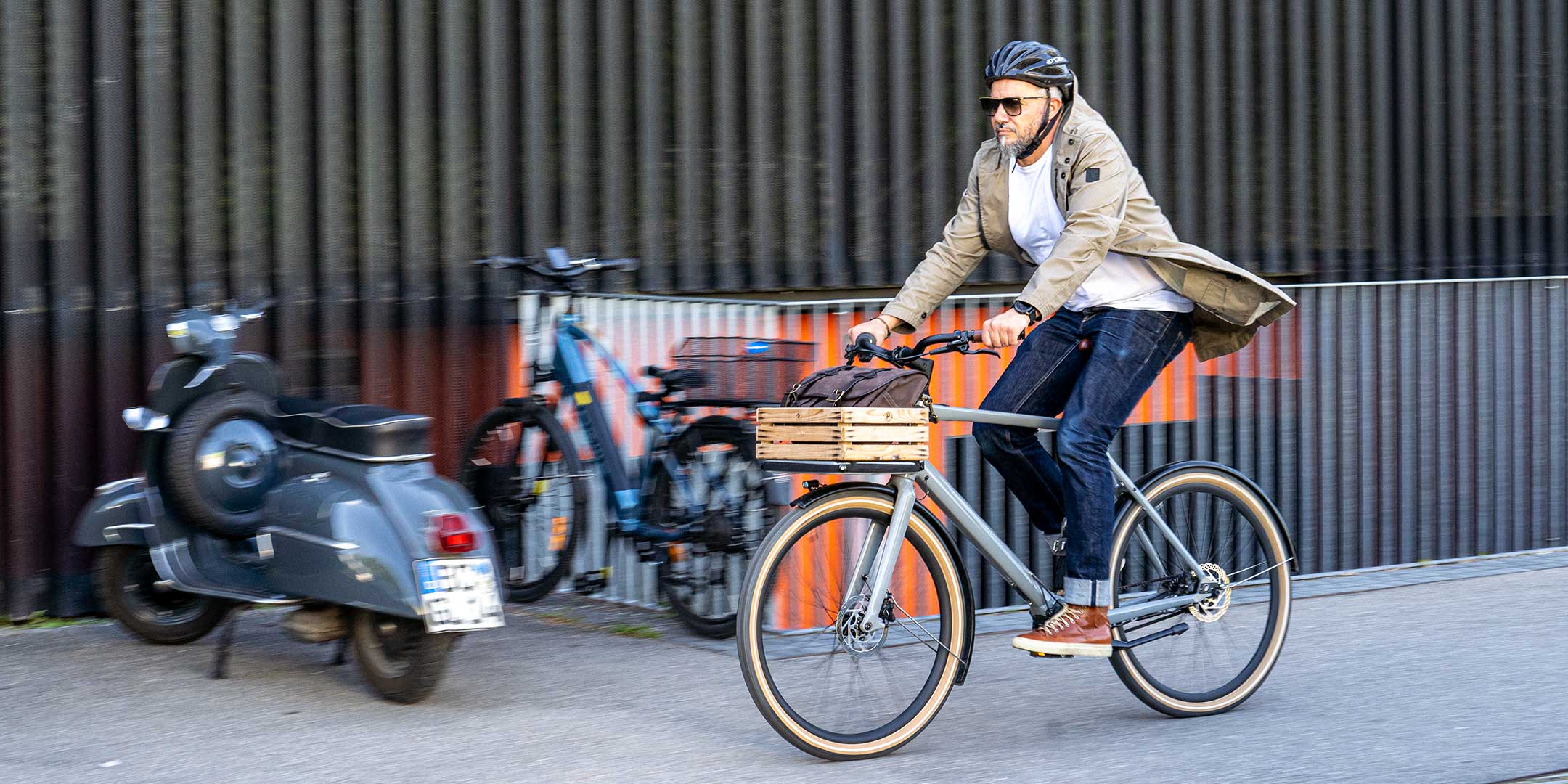 Ein Mann fährt auf einem E-BIKE und trägt einen abriebfesten Parka der Marke For-Legends by Caduff, ideal für urban mobility - for-legends.com. A man rides an E-BIKE wearing an abrasion-resistant parka by For-Legends by Caduff, ideal for urban mobility - for-legends.com.