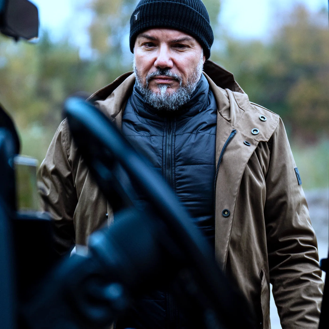 Model in the Beech CADUFF Japanese Double-Knit 2-in-1 Winter Parka approaching a black Land Rover Defender; interior visible in the foreground; premium finish, water-repellent and wind-resistant.