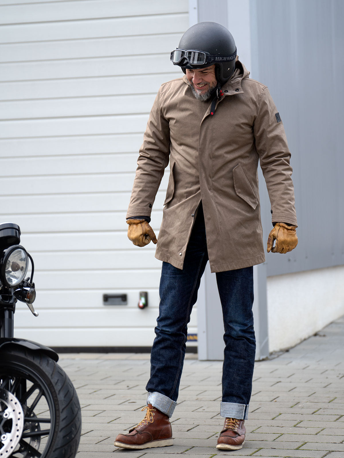 Model wearing a premium insualated and water resistant winter parka from for-legends.com by Caduff, crafted from exclusive high-density knit Japanese fabric, sitting on a harley davidson motorbike in a urban landscape. Perfect for commuting and urban mobility. / Modell trägt einen hochwertigen wasserabweisenden Winterparka von for-legends.com by Caduff aus einem exklusivem High-Density-Jersey aus Japan, sitzend auf einer Harley Davidson in einem urbanen Umfeld. Perfekt für Commuting und Urbane Mobilität.