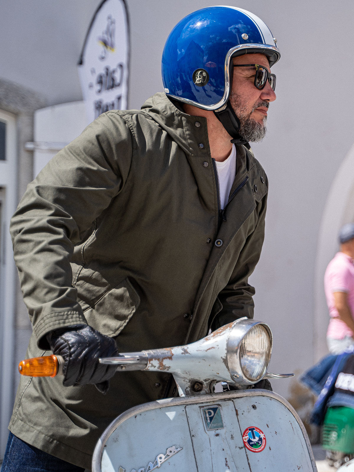 Ein Mann fährt auf einer Vespa | Scooter und trägt einen abriebfesten Parka der Marke For-Legends by Caduff, ideal für urban mobility - for-legends.com. A man rides on a Vespa / Scooter wearing an abrasion-resistant parka by For-Legends by Caduff, ideal for urban mobility - for-legends.com