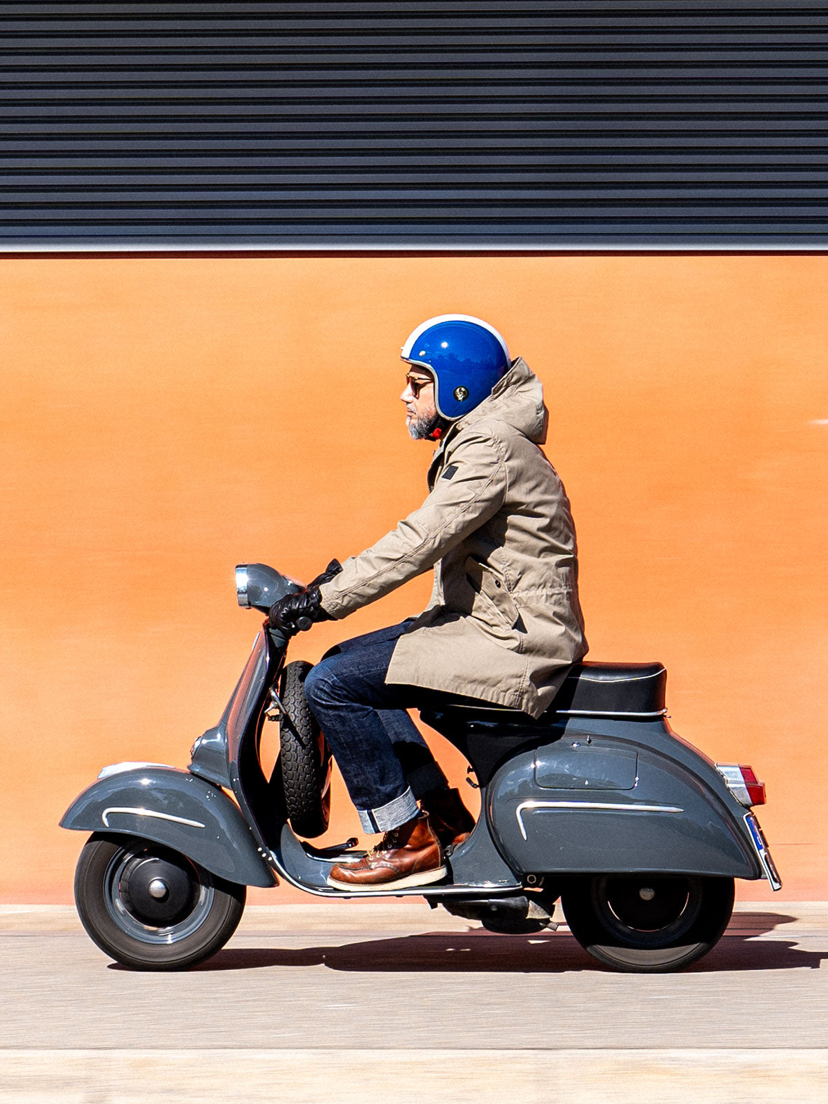 Ein Mann fährt auf einer Vespa | Scooter und trägt einen abriebfesten Parka der Marke For-Legends by Caduff, ideal für urban mobility - for-legends.com. A man rides on a Vespa / Scooter wearing an abrasion-resistant parka by For-Legends by Caduff, ideal for urban mobility - for-legends.com