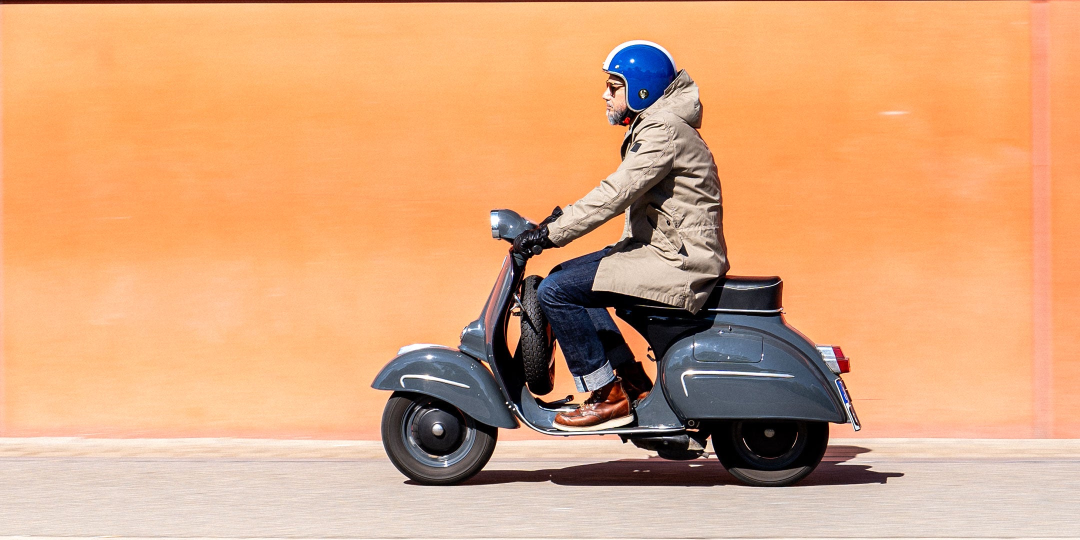 Ein Mann fährt auf einer Vespa | Scooter und trägt einen abriebfesten Parka der Marke For-Legends by Caduff, ideal für urban mobility - for-legends.com. A man rides on a Vespa / Scooter wearing an abrasion-resistant parka by For-Legends by Caduff, ideal for urban mobility - for-legends.com