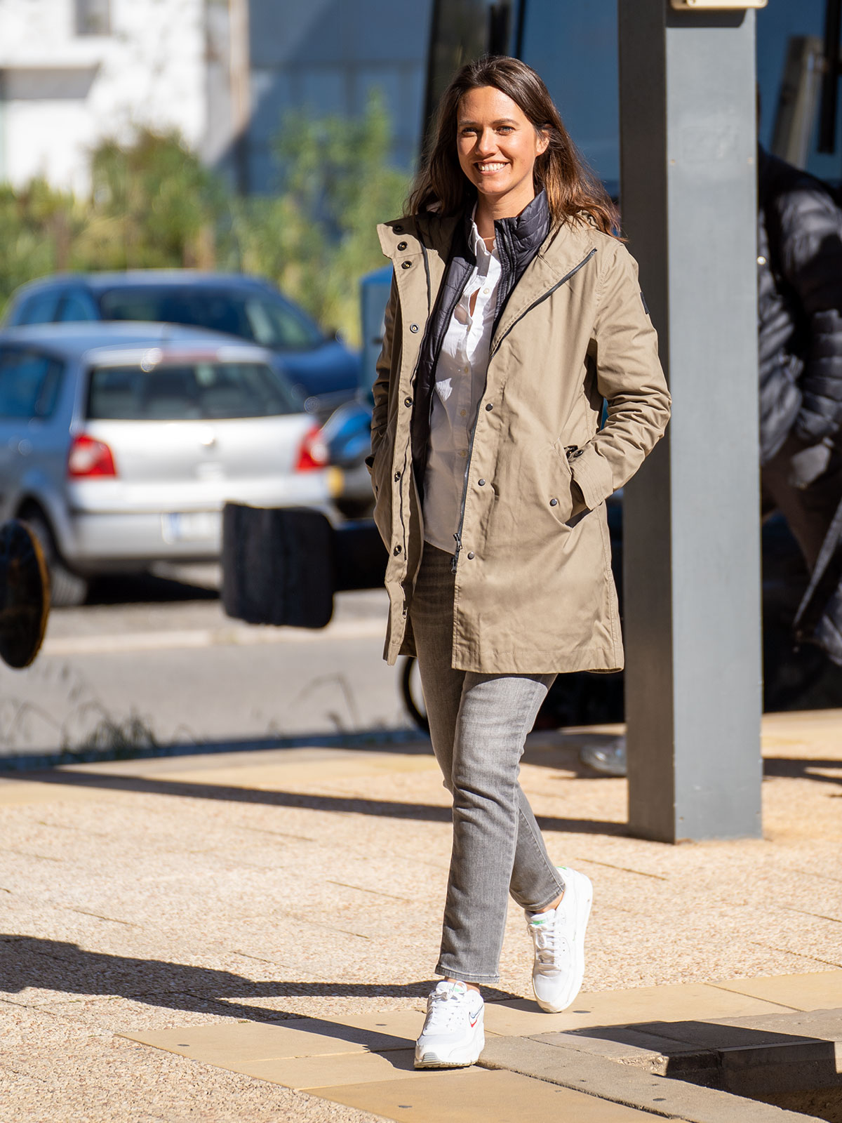WOMAN WALKING IN THE CITY WEARING AN URBAN MOBILITY PARKA WITH AN ABRASSION RESISTANCE UP TO A SPEED OF 45 KM/H